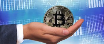 In der rechten Hand hält eine Hand eine Bitcoin Münze.