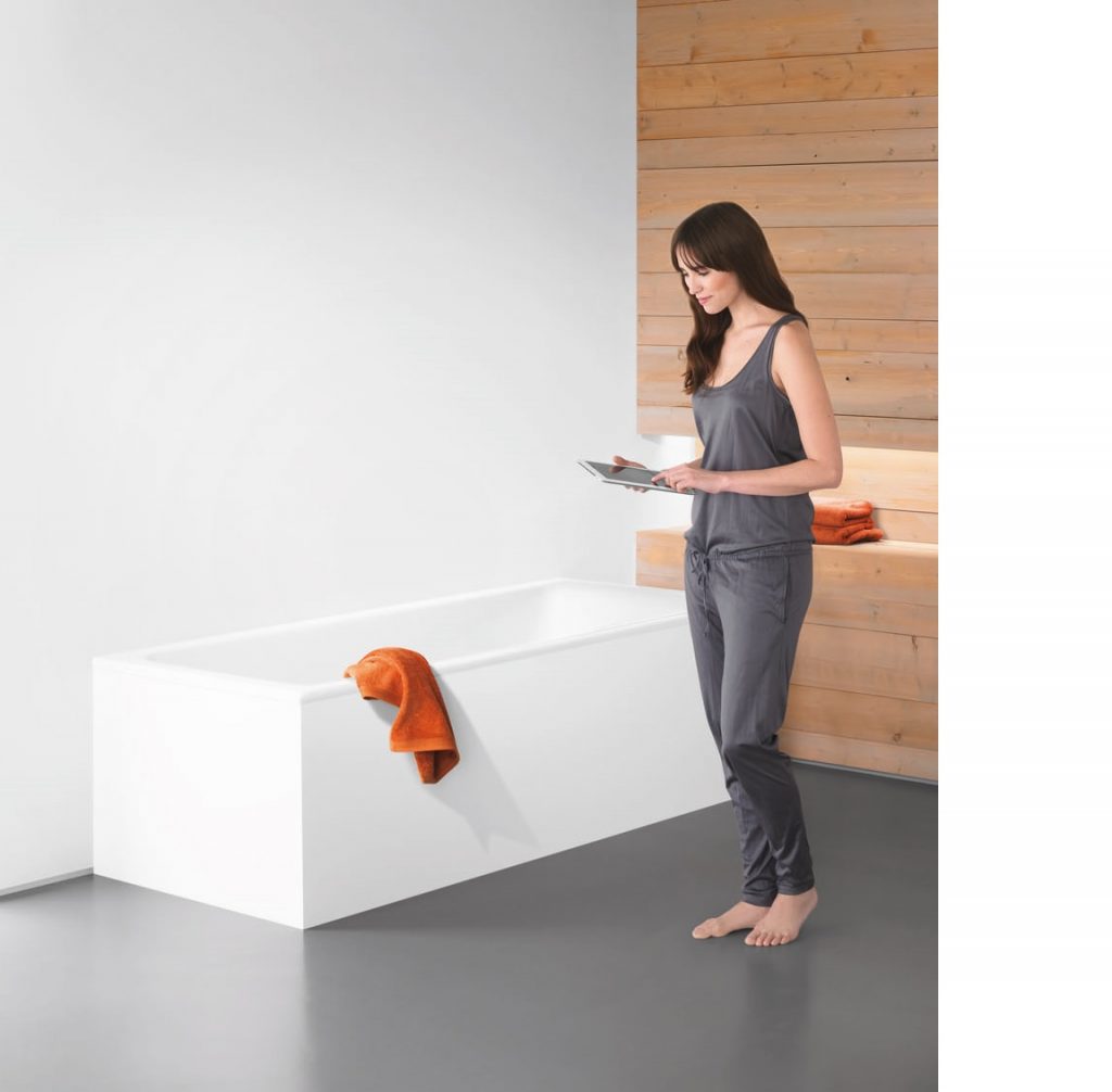 Frau mit schwarzen Haaren steht neben der Wanne