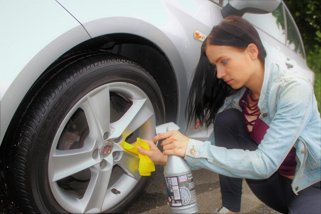 Junge Frau beim Felgen reinigen