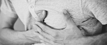 Mann fasst sich ans Herz