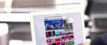 Mann liest Nachrichten am Pc.