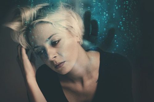 Blonde Frau fast sich an den Kopf