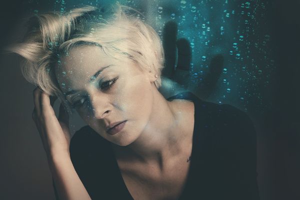 Blonde Frau fast sich an den Kopf