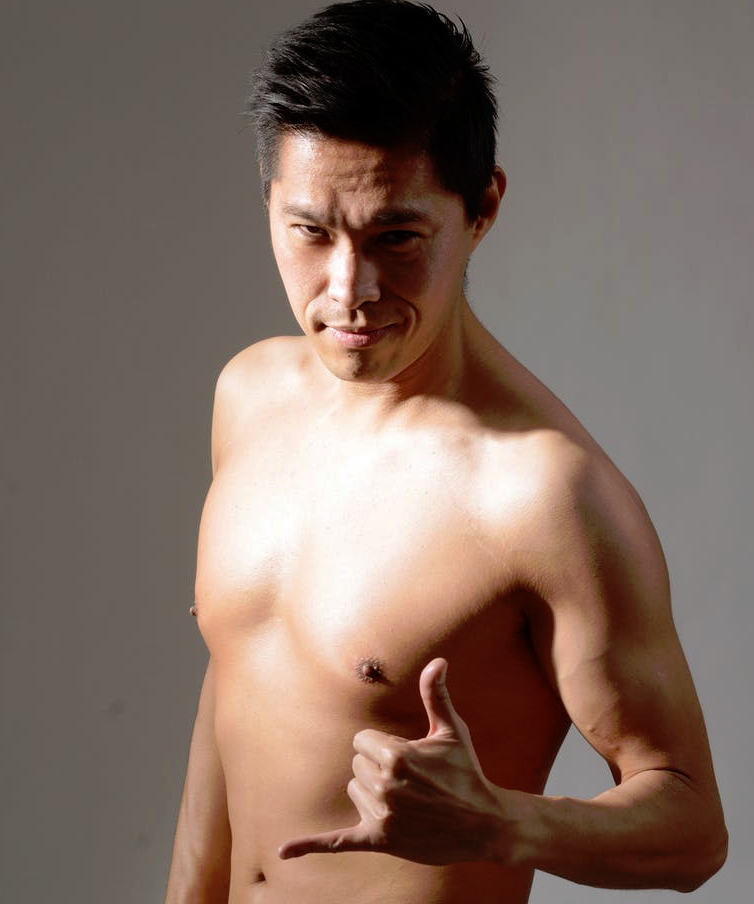 Mann mit freiem Oberkörper streckt Daumen und Finger.