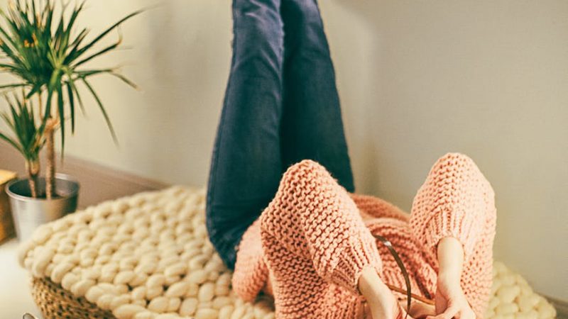 Frau liegt auf dem Boden und fotografiert mit Kamera.