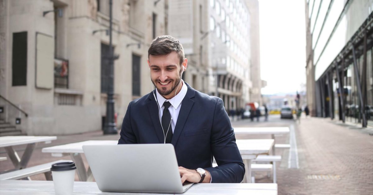 Mann mit Schreibtisch und PC sitzt auf der Straße
