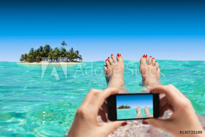 Frau macht Foto mit Smartphone im Urlaub