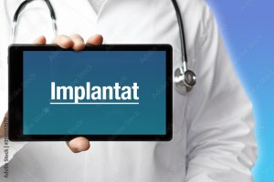 Implantat. Arzt mit Stethoskop hält Tablet-Computer in Hand. Text im Display. Blauer Hintergrund. Krankheit, Gesundheit, Medizin