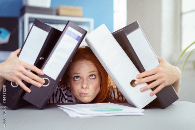 junge frau im büro bricht unter akten zusammen