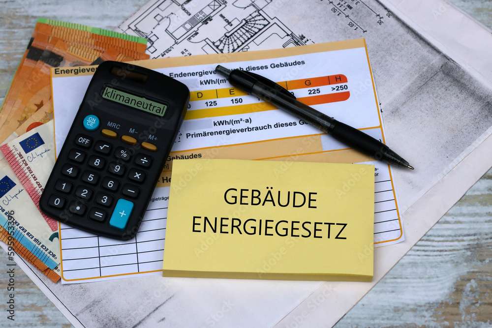 Kosten für Sanierung: Taschenrechner , Energieausweis, Geldscheine und der Text Gebäudeenergiegesetz auf einem Notizblock.