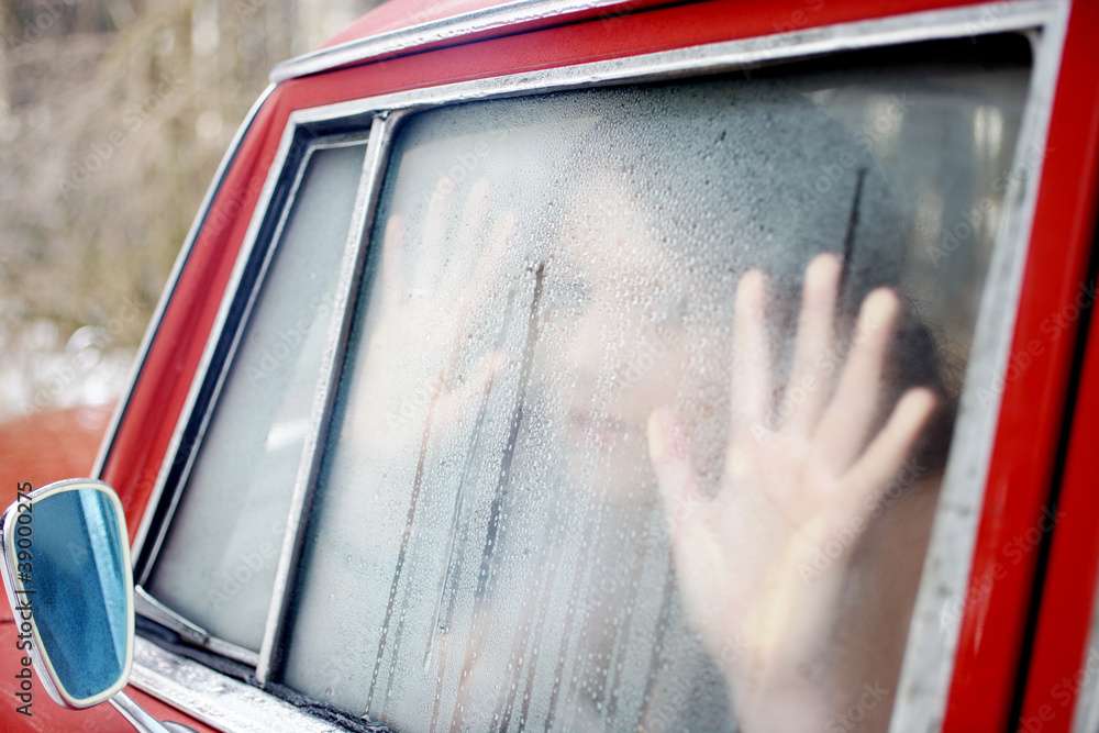 Junges Mädchen in einem roten Oldtimer