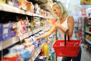 Frau mit rotem Einkaufskorb im Supermarkt