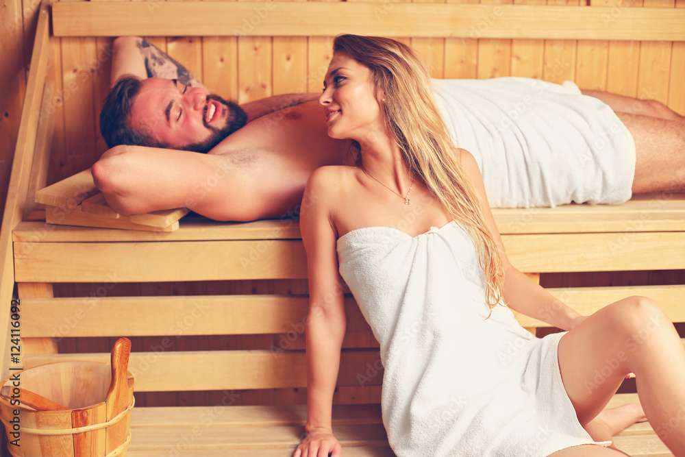 Happy couple relaxing in wooden sauna